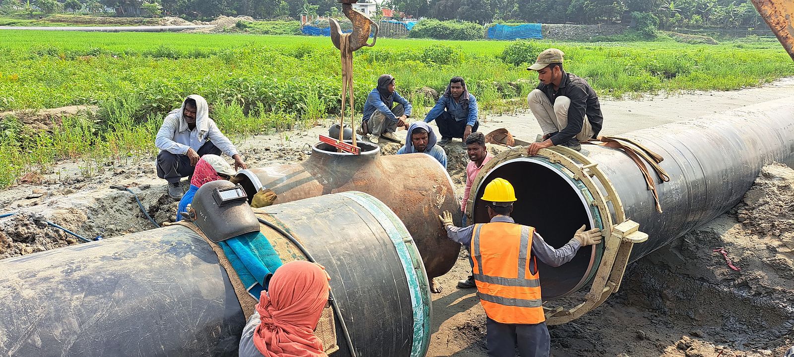 Crew welding a large-diameter steel pipeline in the field